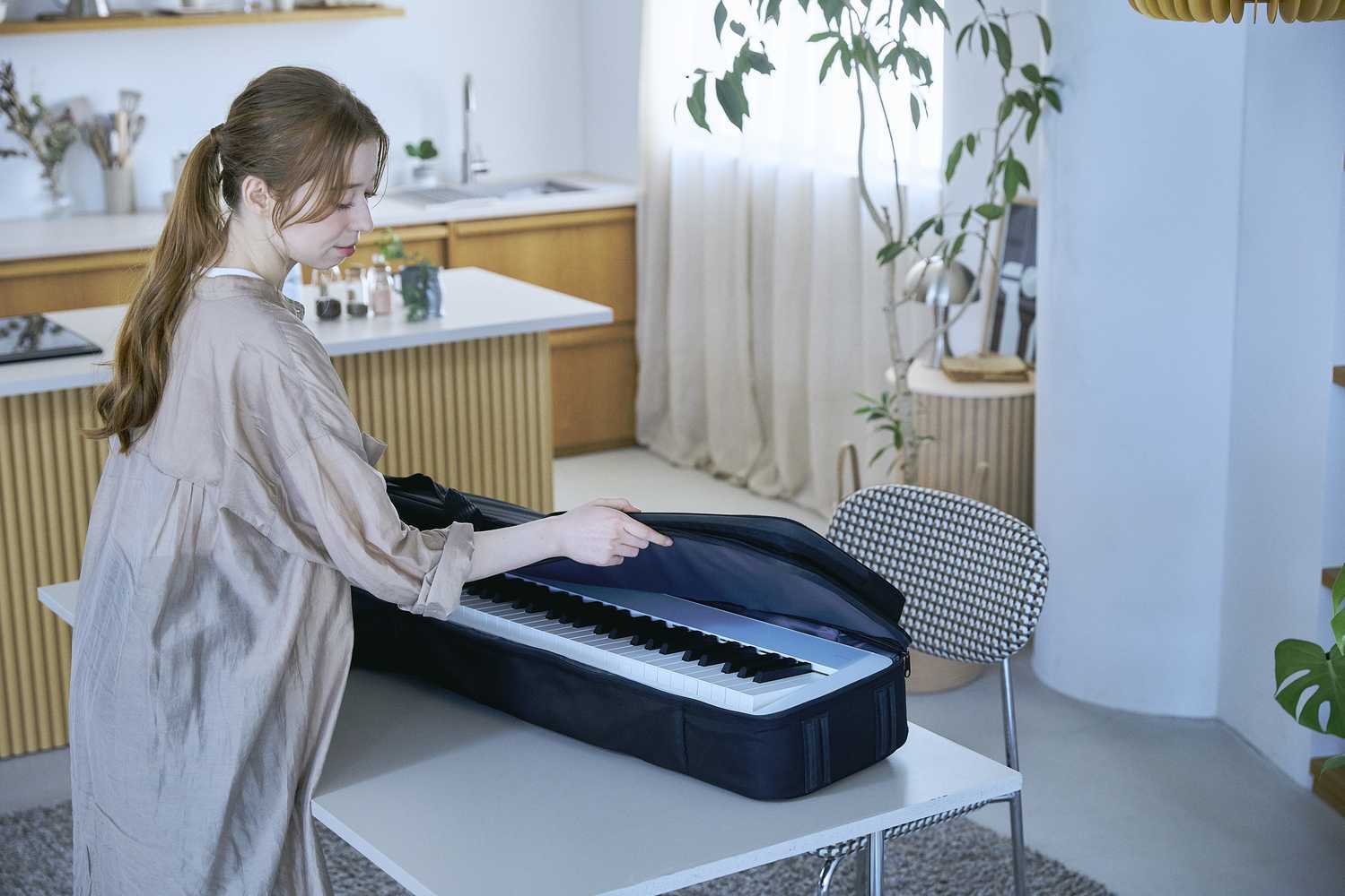Casio Privia PX-S1100CB Lifestyle Frau öffnet Tasche mit Klavier